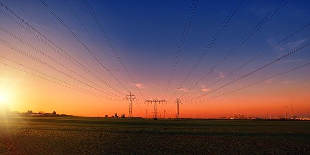 Elektrické vedenie a západ slnka nad poľom
